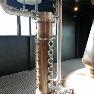 En muista tämän vekottimen nimeä, mutta se liittyy alkoholin erottautumiseen muusta kuparipannun sisällöstä.